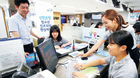 제주여자상업고등학교 학생들이 신한은행에서 개최한 금융교육투어에 참가해 은행 영업점 실무에 대해 경험해 보고 있다.     신한은행 제공